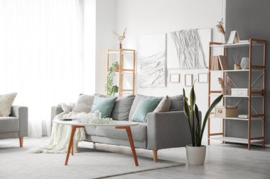 Modern oturma odasının içinde kanepe, masa ve yaratıcı sanat eserleri var.