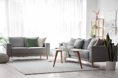 Sofra, masa ve yaratıcı sanat eserleriyle modern oturma odasının içinde.