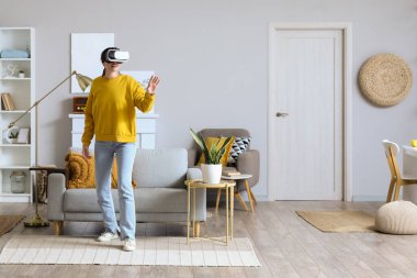 Pretty young woman in VR glasses at home