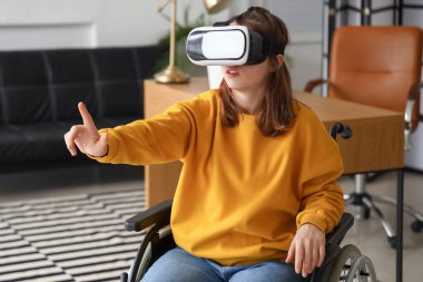 Young woman in wheelchair using VR glasses in office