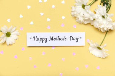 Yazılı kağıt Mutlu Anneler Günü, pullar ve sarı arkaplanda papatya çiçekleri