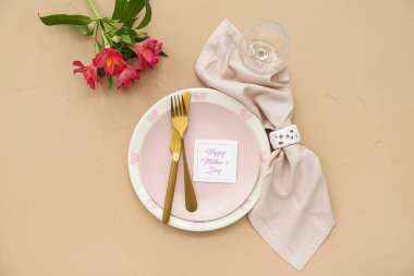 Anneler Günü kutlamaları için arkaplandaki mersin çiçekleriyle süslü sofra.