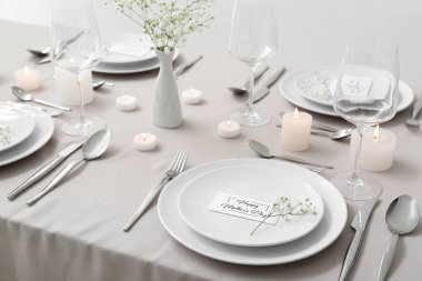 Anneler Günü kutlaması için çingene çiçekleri ve masada yanan mumlarla.