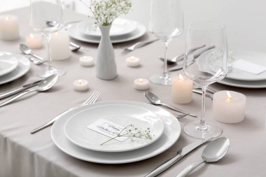 Anneler Günü kutlaması için çingene çiçekleri ve masada yanan mumlarla.