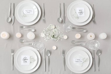 Anneler Günü kutlaması için çingene çiçekleri ve masada yanan mumlarla.