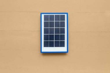 Portable solar panel on beige wooden background