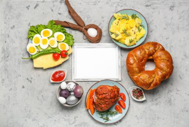 Composition with blank picture frame and tasty dishes for Easter dinner on grunge background