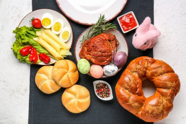 Easter table setting with tasty dishes on light background