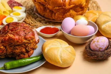 Tasty dishes and painted eggs for Easter dinner on color background, closeup