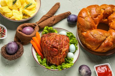 Tasty dishes and beautiful painted eggs for Easter dinner on grunge background