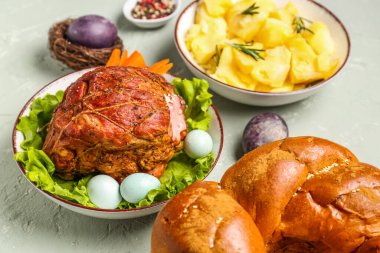 Tasty dishes and beautiful painted eggs for Easter dinner on grunge background, closeup