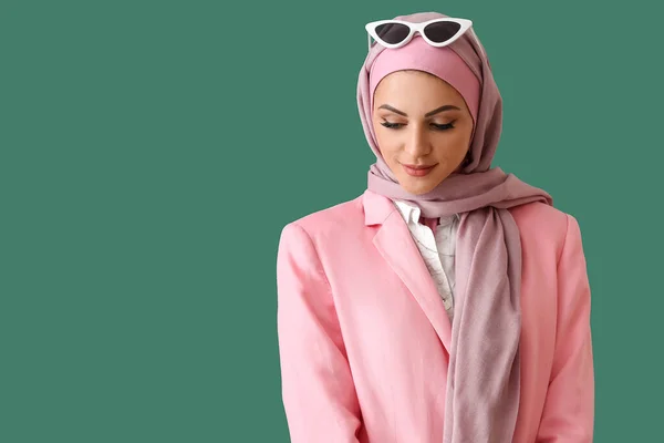 スタイリッシュなイスラム教徒女性でピンクヒジャーブ上の緑の背景 — ストック写真
