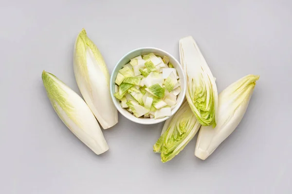 Composition with bowl of cut fresh endive on white background