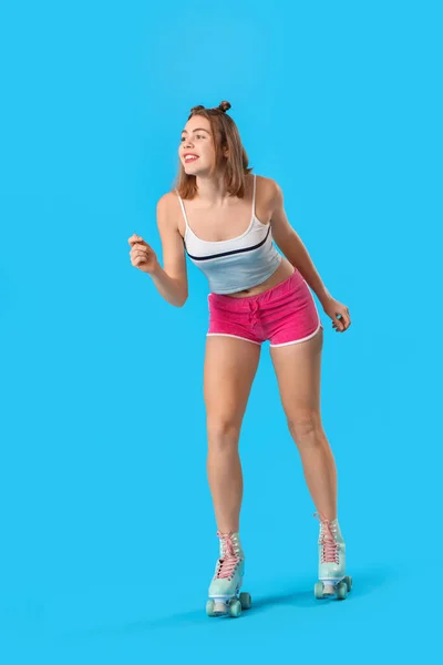 魅力的な若いです女性でローラースケート上の青の背景 — ストック写真