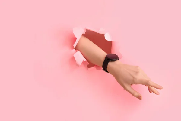 Kobieta Ręka Smartwatch Widoczne Przez Podarty Różowy Papier — Zdjęcie stockowe