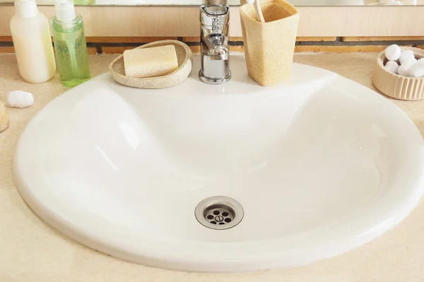 房间里有白色陶瓷洗涤槽和浴室用品的桌子 特写镜头 — 图库照片