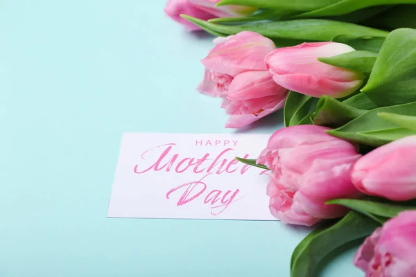 stock image Greeting card with text HAPPY MOTHER'S DAY and beautiful tulip flowers on turquoise background