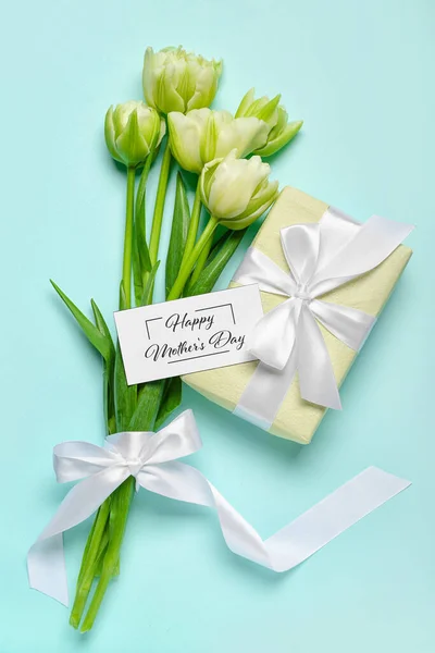 Greeting card with text HAPPY MOTHER\'S DAY, gift box and beautiful tulip flowers on turquoise background