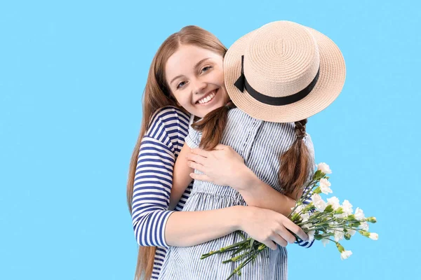Mujer Joven Abrazando Hijita Con Flores Sobre Fondo Azul Celebración — Foto de Stock