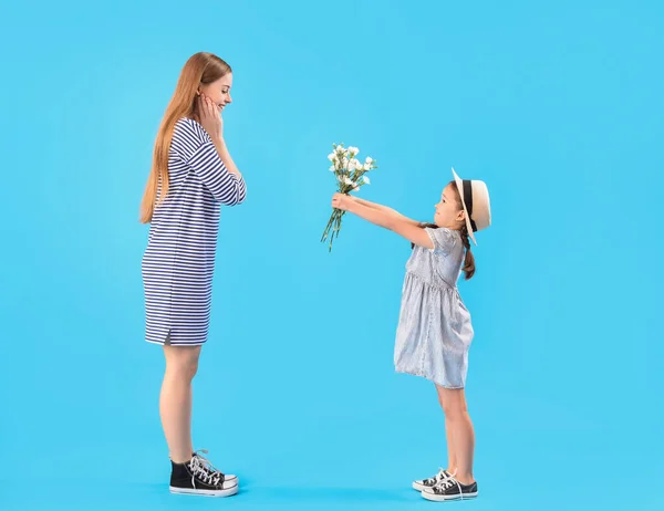 Cute Little Girl Greeting Her Mother Flowers Blue Background — Stock Photo, Image