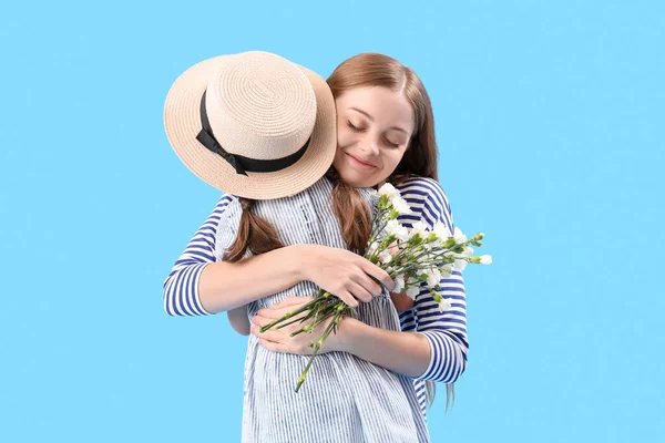 Ung Kvinna Kramar Sin Lilla Dotter Med Blommor Blå Bakgrund — Stockfoto