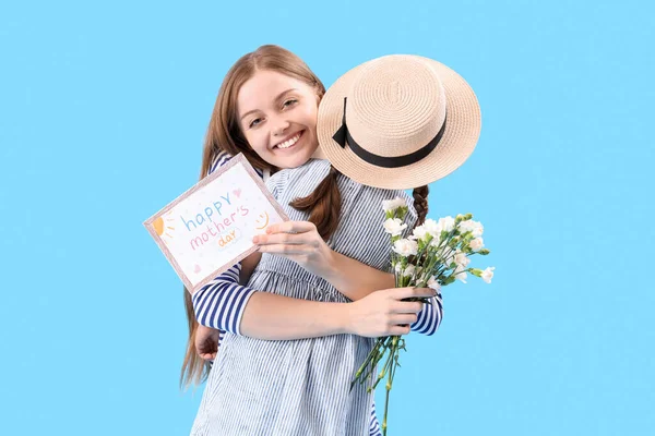 Junge Frau Umarmt Ihre Kleine Tochter Mit Blumen Und Grußkarte — Stockfoto