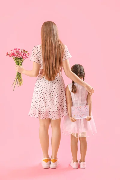 带着母亲节贺卡的可爱小女孩和粉红背景的妈妈 — 图库照片
