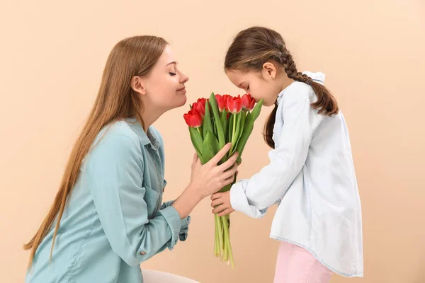 Cute Little Girl Greeting Her Mother Tulips Beige Background — Stock Photo, Image