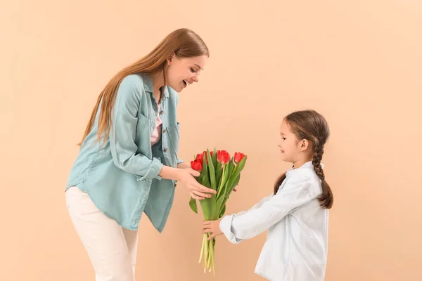 Cute Little Girl Greeting Her Mother Tulips Beige Background — Stock Photo, Image
