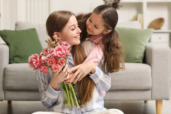 放假的时候 可爱的小女孩抱着妈妈在家里放着花 — 图库照片
