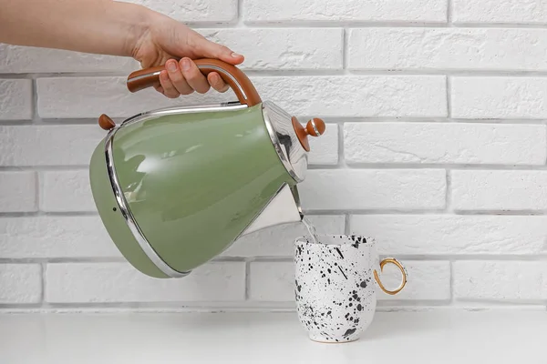 Woman Pouring Boiled Water Kettle Cup White Brick Wall — Stock Photo, Image