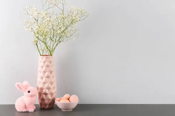 Virágos Váza Húsvéti Tojás Nyúl Asztalon Szürke Fal Mellett — Stock Fotó