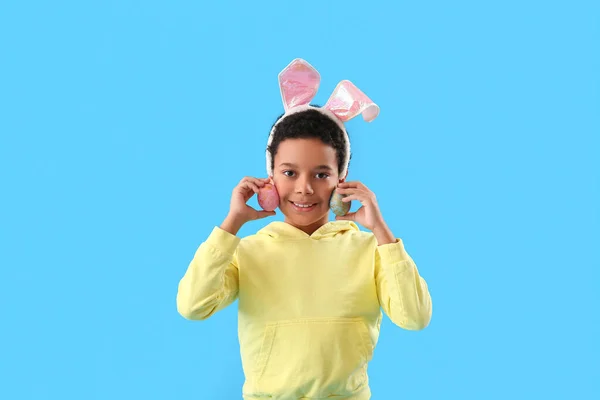 アフリカ系アメリカ人の男の子でウサギの耳でイースターエッグ上の青の背景 — ストック写真