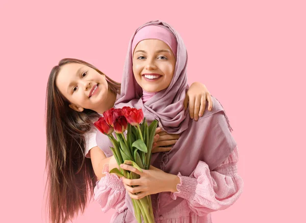 Kislány Muszlim Anyja Tulipánnal Ölelés Rózsaszín Háttér — Stock Fotó