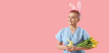 Young woman with bunny ears, Easter rabbit and tulips on pink background with space for text