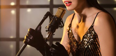 Young woman singing in microphone on stage