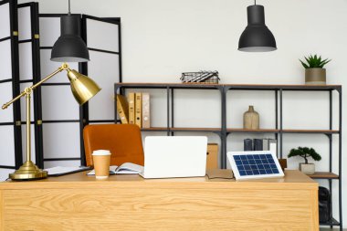 Workplace with portable solar panel and laptop in office