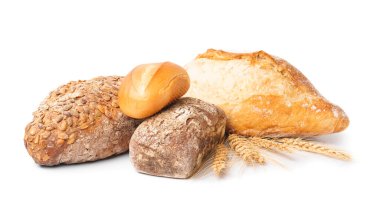Loaves of different bread and wheat ears isolated on white background