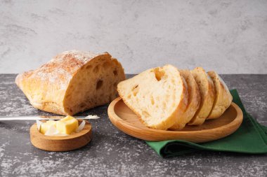 Plate with pieces of fresh bread on grey table