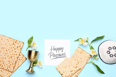 Composition with card, flatbread matza, cup, kippah and alstroemeria flowers on color background