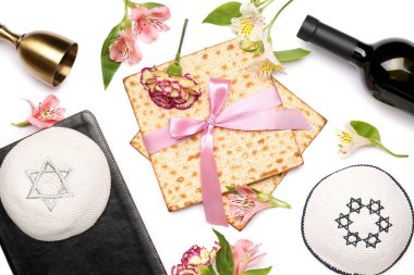 Flatbread matza, kippah, alstroemeria çiçeği ve beyaz arka planda bir şişe şarap ile kompozisyon
