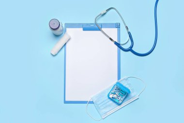 Blank clipboard with medical supplies on blue background. World Health Day