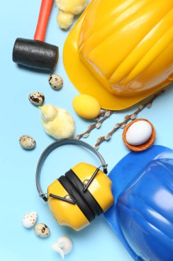 Tavuklu inşaat aletleri, paskalya yumurtaları ve mavi arka planda söğüt dalları.