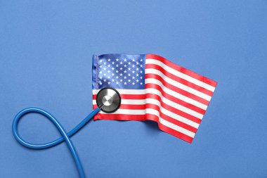 Stethoscope and USA flag on blue background