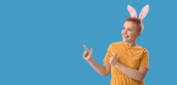 Young Woman Easter Bunny Ears Pointing Something Blue Background Space — Fotografia de Stock