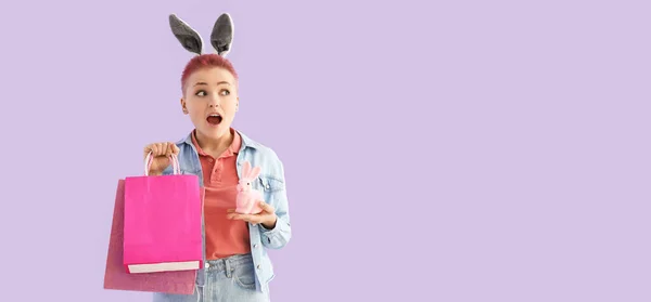 Surprised Young Woman Shopping Bags Easter Bunny Lilac Background Space — Stockfoto