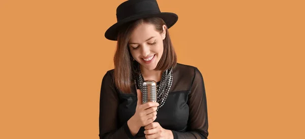 Beautiful Young Female Singer Microphone Orange Background — стоковое фото