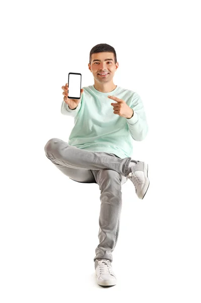 Красивий Хлопець Вказує Мобільний Телефон Кріслі Білому Тлі — стокове фото