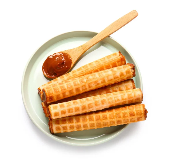 Plate of delicious wafer rolls with boiled condensed milk isolated on white background