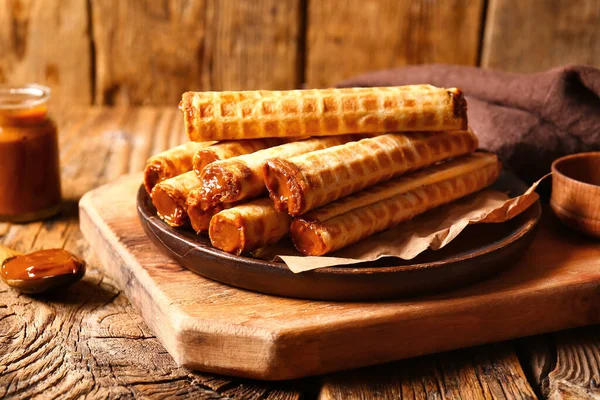 Plate Delicious Wafer Rolls Boiled Condensed Milk Brown Wooden Table — Stock Photo, Image